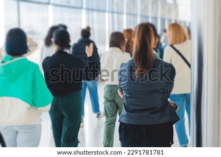 Group of students on excursion visit gallery museum with tour guide, a docent with a tourist adult visitors on an archaeology exhibition with contemporary art, paintings and exhibits
