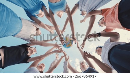 Group of students reaching for a globe, symbolizing their commitment to environmental protection and global citizenship