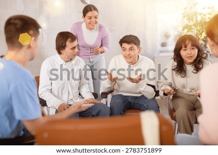 Group of students sitting in circle studying together in study hall of university