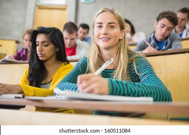 Group Of Students Sitting At The Lecture Hall While Writing