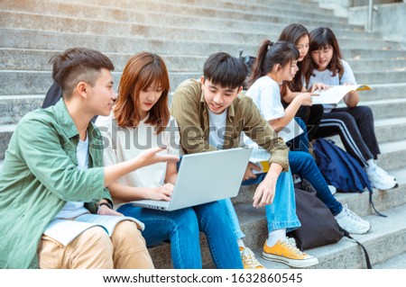 Group of students studying on the stairs  at campus