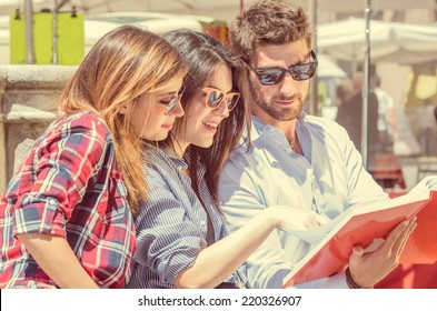 group of students. two girls and one boy studying with interest on a book  - Powered by Shutterstock