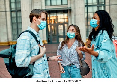 A Group Of Students Wearing Protective Medical Masks Talk Outside The Campus.