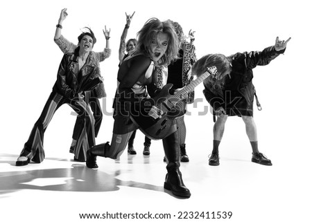Group of stylish people, man and woman, rock musicians performerming over white background. Black and white photography. Concert. Concept of music, rock and roll, lifestyle, fashion. Copy space for ad