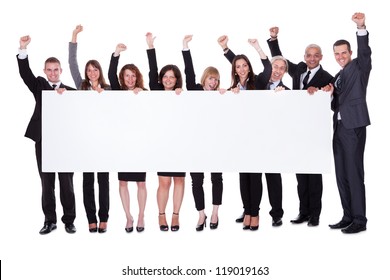 Group of stylish professional business people standing in a line holding up a long blank banner for your advertising or text - Powered by Shutterstock