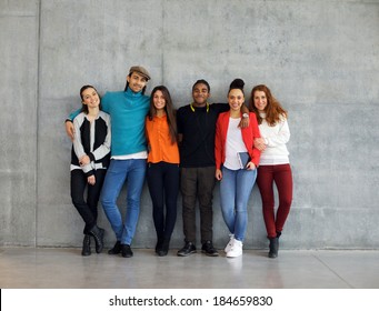 Group Of Stylish Young University Students On Campus. Multiracial Young People Standing Together Against Wall In College.