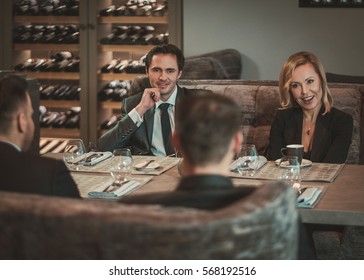 Group Of Successful Business People Discussing During Business Dinner In Restaurant.