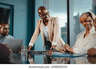 Group of successful business people having a meeting in an office setting. A businesswoman is leading a discussion with the rest of the team. They are engaged and focused on their work. - Powered by Shutterstock