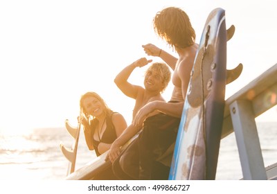 Group of surfers chilling out on the beach. sitting on the lifeguard house and having fun - Powered by Shutterstock