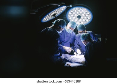 Group Of Surgeons In Hospital Operating Theater. Medical Team Performing Surgery In Operation Room.