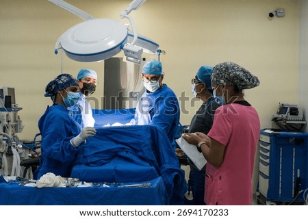 Group of surgeons and nurses collaborating during a surgical procedure in a hospital operating room.