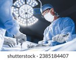 Group of surgeons at operation in operating room at hospital. Surgery, medicine and people concept. Medical case, urgent treatment, microsurgery concept