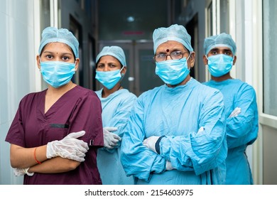 group of surgeons and practitioners confident standing with arms crossed by looking camera at hospital corridor - concept of healthcare and medical service