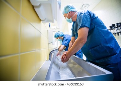 Group of surgeons washing their hands at washbasin in hospital - Powered by Shutterstock