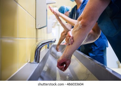 Group of surgeons washing their hands at washbasin in hospital - Shutterstock ID 486033604