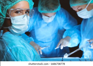 Group of surgeons wearing safety masks performing operation. Medicine concept - Powered by Shutterstock