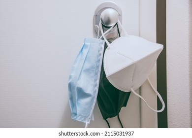 Group Of Surgical Masks Hung On The Home Door Handle. Closeup View Of Face Mask During Coronavirus Quarantine Lockdown. Covid-19, Health, Healthcare, Protection, Contagion, Disease, Isolation Concept