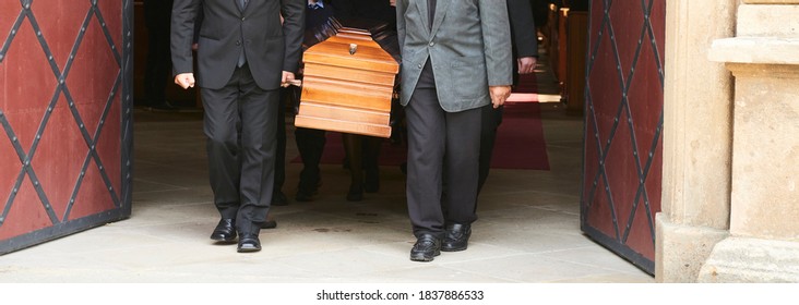 Group of survivors carries a coffin out of the church after a funeral mass