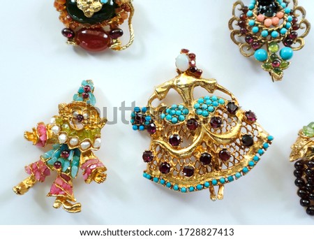 A group of Swoboda vintage brooch made from a variety of colourful semi-precious stones in gold.