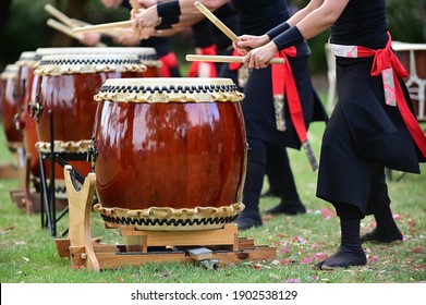 Group Of Taiko Drummers Drumming On Japanese Drums Together.