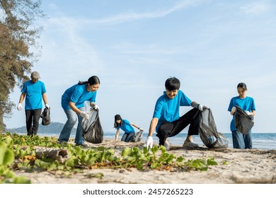 Group teamwork volunteer pick up the plastic bottle on the beach. People male and female Volunteer with garbage bags clean the trash on the beach make the sea beautiful. World environment day CSR. - Powered by Shutterstock