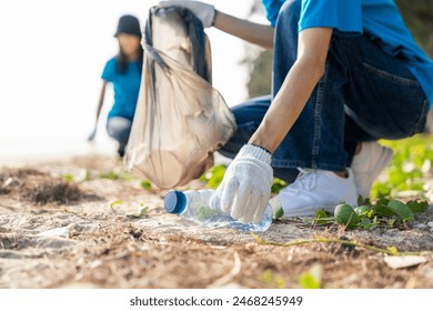 Group teamwork volunteer pick up the plastic bottle on the beach. People male and female Volunteer with garbage bags clean the trash on the beach make the sea beautiful. World environment day CSR. - Powered by Shutterstock