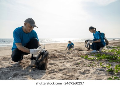 Group teamwork volunteer pick up the plastic bottle on the beach. People male and female Volunteer with garbage bags clean the trash on the beach make the sea beautiful. World environment day CSR. - Powered by Shutterstock