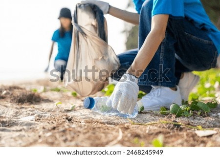 Group teamwork volunteer pick up the plastic bottle on the beach. People male and female Volunteer with garbage bags clean the trash on the beach make the sea beautiful. World environment day CSR.