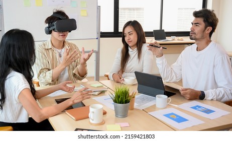 A group of tech developers having a meeting in the office, discussing and testing the new version of virtual game on VR glasses.