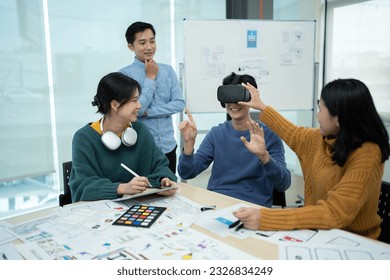 A group of tech developers having a meeting in the office, discussing and testing the new version of virtual game on VR glasses. - Powered by Shutterstock