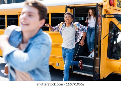 Group Of Teen Students Running Out Of School Bus