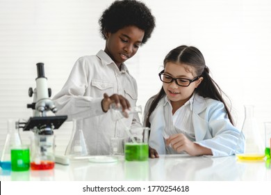 Group of teenage cute little students child learning research and doing a chemical experiment while making analyzing and mixing liquid in test tube at experiment laboratory class at school.Education - Powered by Shutterstock