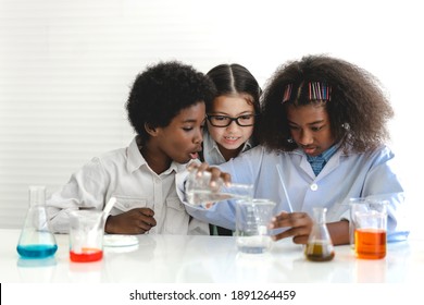 Group of teenage cute little students child learning research and doing a chemical experiment while making analyzing and mixing liquid in test tube at experiment laboratory class at school.Education - Powered by Shutterstock