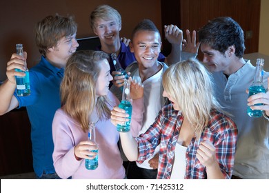 Group Of Teenage Friends Dancing And Drinking Alcohol