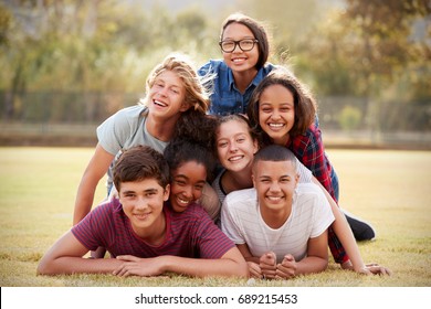 Group Of Teenage Friends Lying In A Pile On Grass