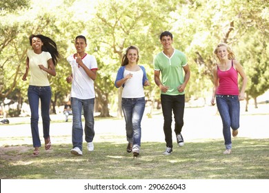 Group Of Teenage Friends Running In Park