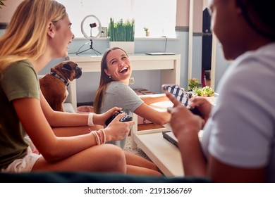 Group Of Teenage Girl Friends With Mobile Phones Gaming And Hanging Out In Bedroom At Home