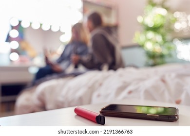 Group Of Teenage Girls In Bedroom With Vape Pen And Mobile Phone In Foreground