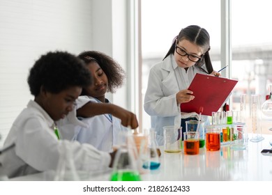 Group of teenage student learn with teacher and study doing a chemical experiment and holding test tube in hand in the experiment laboratory class on table at school.Education concept