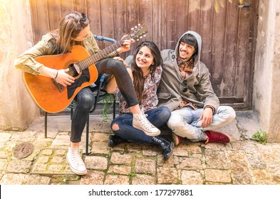 Group Of Teenager Friends Having Fun Playing Guitar