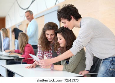 Group Of Teenagers In Classroom With Electronic Tablet