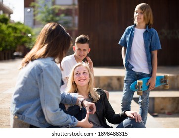 Group Of Teenagers Communicate In Schoolyard