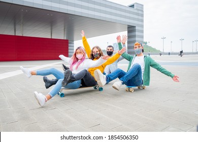 Group of teenagers covered by  face masks fooling about at skate park - Multiracial students sitting on skateboard at college campus - Concepts lifestyle about teenage during pandemic covid19. - Powered by Shutterstock