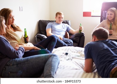Group Of Teenagers Drinking Alcohol In Bedroom