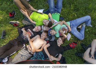 A Group Of Teenagers Is Lying On The Lawn In The Grass. Rybinsk, Yaroslavl Region, Russia. Camp Vysokovsky Bor 16.06.2021.