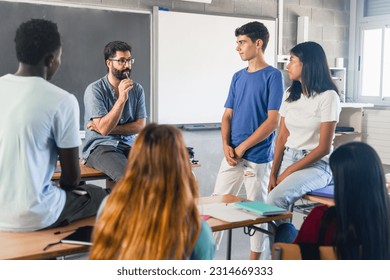 Group of teenagers and male teacher at classroom talking and discussing together - Powered by Shutterstock