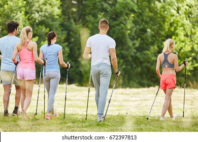 Group Of Teenagers Nordic Walking In Hiking Trip