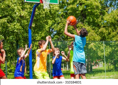 Group of teenagers play basketball on playground