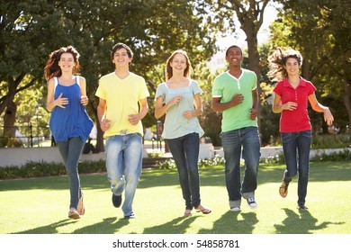 Group Of Teenagers Running Through Park