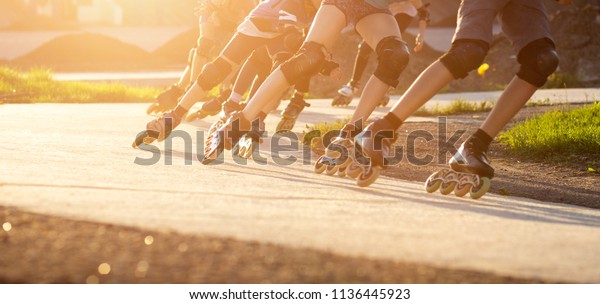 Group of
teenagers skating on track in summer evening. Abstract panoramic
short track speed skating sport
background